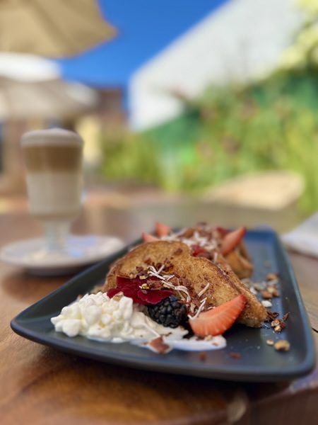 Pan francés relleno con fresas, moras y crema, servido en el jardín